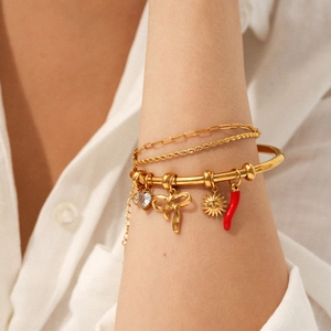 Gold layered stainless steel bracelet set with sun, heart, and chili charms on a model