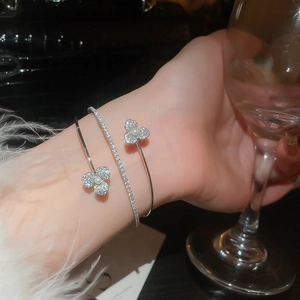 Detail of silver double-layered cuff bracelet with zircon flower and white pearl