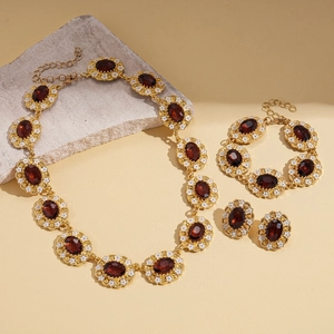 Vintage gold jewelry set with red gemstones and white enamel floral oval pendants