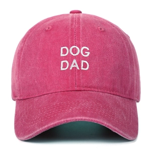 Detailed view of white DOG DAD embroidery on a vintage pink washed cotton baseball cap