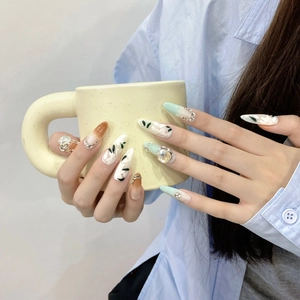 Luxury handmade press-on nails with green gradients, floral art, and 3D rhinestones