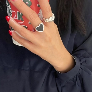 S925 silver ring set with black heart agate and twisted band on hand holding coffee cup