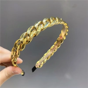 Chic gold-plated metal chain headband with black end tips on a neutral background