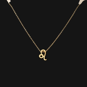 Close-up of golden Leo zodiac sign pendant necklace with polished finish on black background