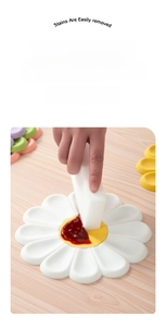 Daisy silicone trivet showing water and oil resistant surface being wiped clean