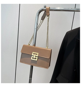 Detail of light brown square shoulder bag with gold geometric metal buckle and chain strap