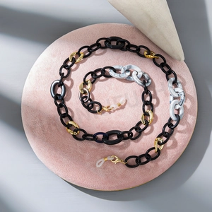 Detailed macro view of acrylic eyewear chain with black and marble textured links