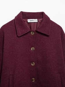 Close-up of lapel and collar detail on a burgundy wool-textured single-breasted coat
