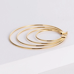 Close-up of golden multi-layer circular earrings with a polished metallic finish