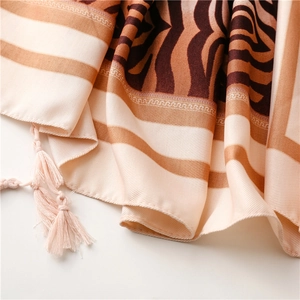 Detailed close-up of zebra print scarf with brown stripes and delicate fringe edges