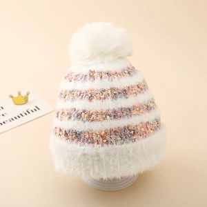 Détail de la texture en maille du bonnet d'hiver rayé rose et blanc avec pompon doux