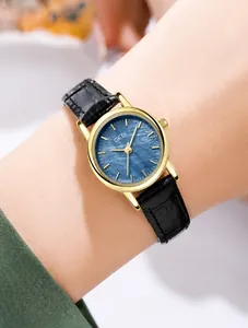 Nahaufnahme einer minimalistischen Damen-Golduhr mit dunkelblauem Zifferblatt und Lederarmband