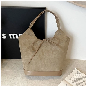 Close-up of khaki suede tote bag with smooth PU leather trim and front bow detail