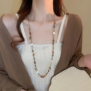 Dettaglio della collana vintage con perline, pietre e frange di monete retrò