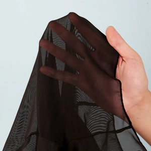 Detail shot of sheer black micro mesh fabric showing high elasticity and transparency