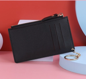 Detail of lychee textured leather card holder with gold zipper and keychain ring