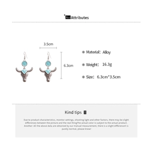 Detailed view of bohemian bull head earrings in vintage silver with blue enamel