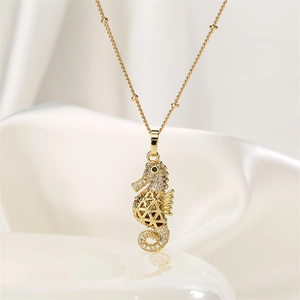 Macro view of golden seahorse pendant with pavé zircon stones and hollow-out mesh design