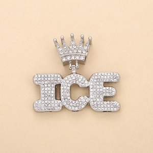 Close-up of iced out crown and ICE word pendant necklace with silver plating and rhinestones