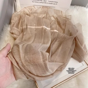 Close-up of champagne silk wool scarf featuring gold metallic stripes and soft texture