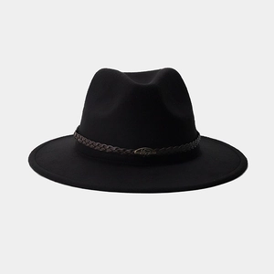 Détail du chapeau fedora noir avec bande en cuir marron et logo de buffle en métal rétro