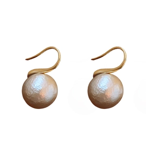 Boucles d'oreilles élégantes en perles plaquées or avec une finition texturée sur fond blanc