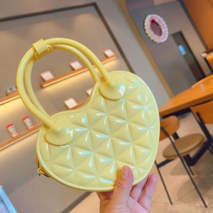 Detail of yellow heart-shaped PVC jelly bag featuring a classic quilted lattice pattern