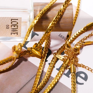 Macro shot of 18K gold plated titanium necklace clasp showing textured snake chain links