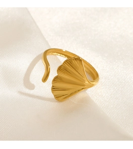 Macro view of gold ginkgo leaf ring texture on smooth white silk fabric background