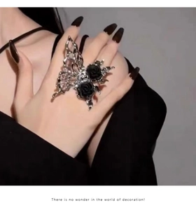 Detail of a Gothic butterfly ring with hollow wings and black roses on silver alloy band