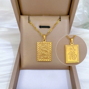 Close-up of gold titanium steel pendant with dragon relief and Fu character detail
