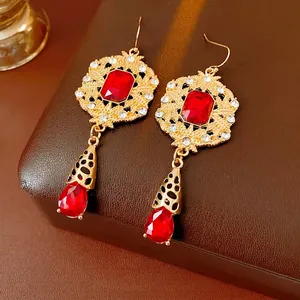 Vintage style gold earrings with emerald-cut red gemstones and crystal accents