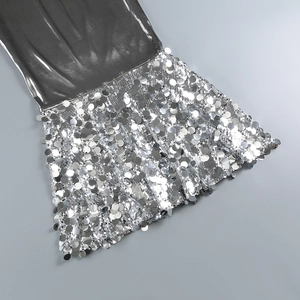 Detailed view of shimmering silver sequins and tassel fringe on a luxury cocktail dress