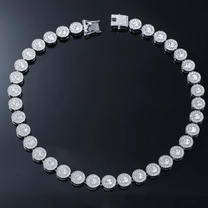 Detailed close-up of a silver hip hop chain with iced-out clear zircons on black background