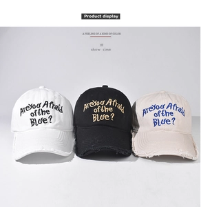 Detailed embroidery and distressed frayed edges on washed cotton baseball caps