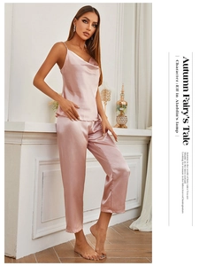 Detail of elegant dusty pink satin pajamas set with camisole top and straight leg trousers