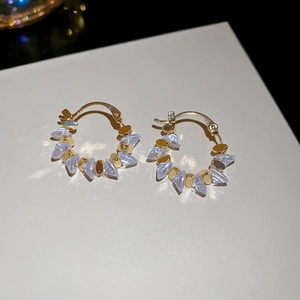 Close-up of 18k gold plated hoop earrings with purple crystal charms on white background