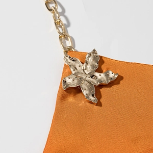 Abito lungo in raso arancione con spalline a catena dorata e fibbia a forma di stella