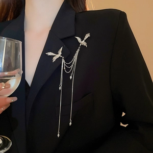 Elegante spilla a uccello argentata con nappe di perle su una giacca da abito nera
