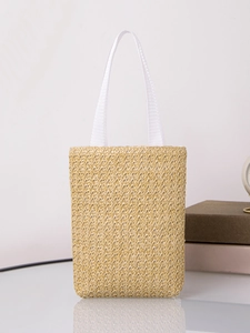 Close-up of beige woven straw tote bag with white handles on a minimalist background