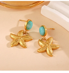 Detail of starfish earrings with turquoise studs and gold-plated finish sea style