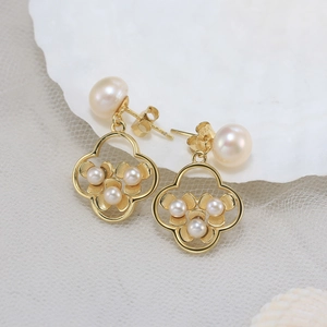 Detailed macro view of S925 silver gold-plated flower earrings with white freshwater pearls