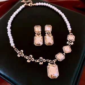 Elegant vintage jewelry set featuring pearl necklace and champagne gemstone earrings