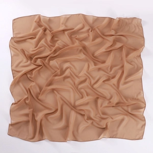 Detail of earth brown chiffon square hijab showing soft texture and rolled edge