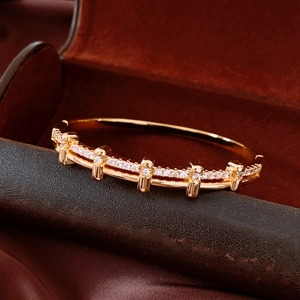 Détail macro du bracelet plaqué or 18 carats avec zircons pavés sur un support de luxe