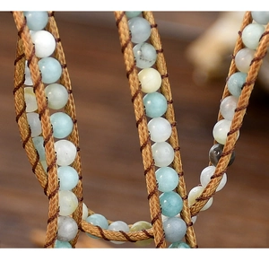 Macro shot of Bohemian 5-layer wrap bracelet featuring light blue stone beads and braided cord