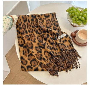 Detail shot of leopard print cashmere scarf showing soft texture and tassel design
