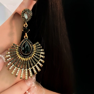 Close-up of vintage gold tassel earrings with black teardrop rhinestones on model