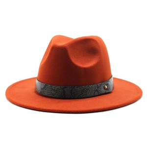 Detail of orange fedora wool hat featuring dark grey snakeskin band and gold metal rivet