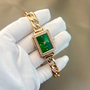 Close-up of women's vintage square green dial watch with gold crystal-studded bracelet